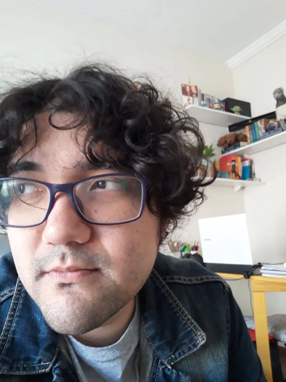 Person with curly hair and glasses.