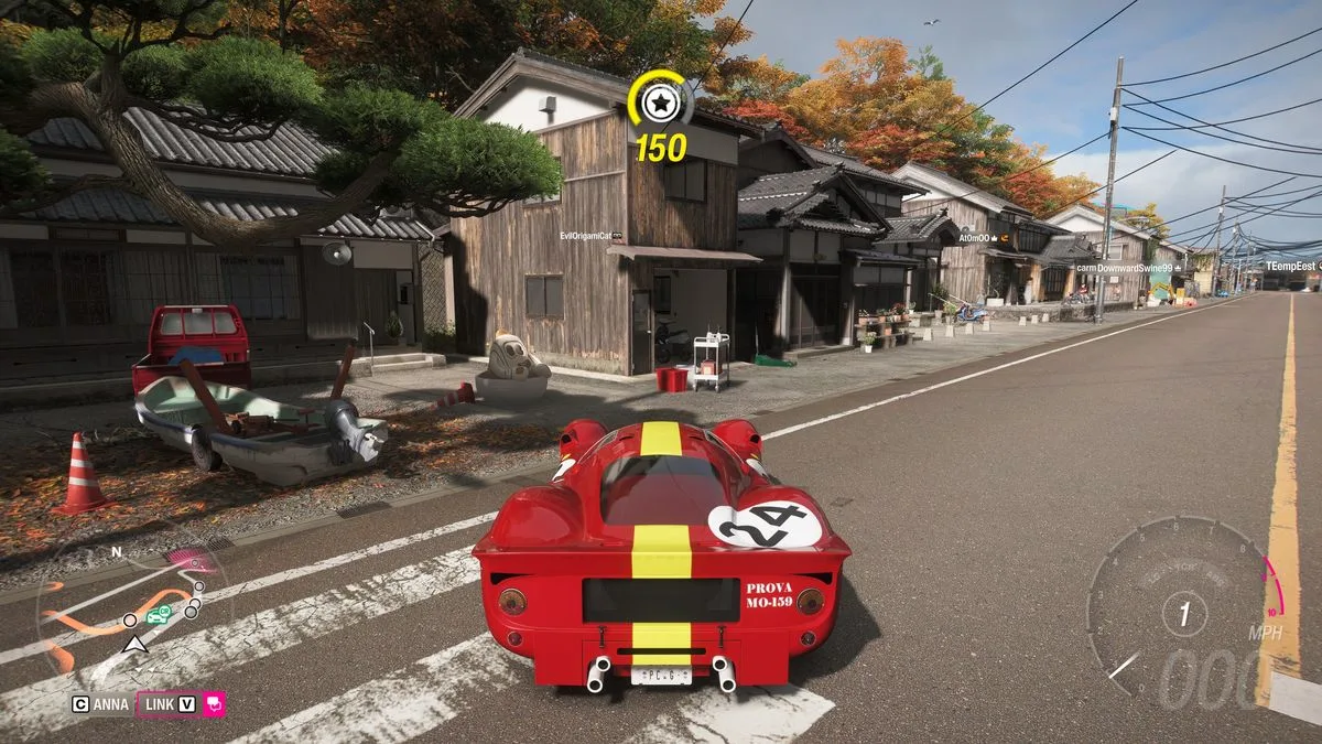FH6 tank latte: A classic red Ferrari parked on a main road opposite a large latte mascot next to a house.