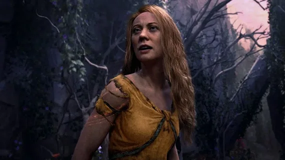 A pale-skinned woman with long blonde hair stands in an overgrown ruin with a concerned look on her face. It's Faye in God of War Laufey.