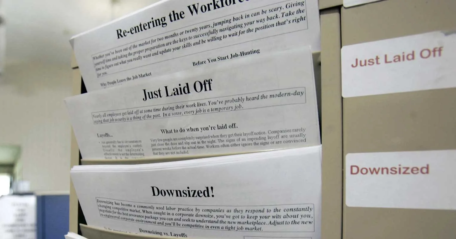 Filing cabinet with documents about layoffs and downsizing. Job loss concept.
